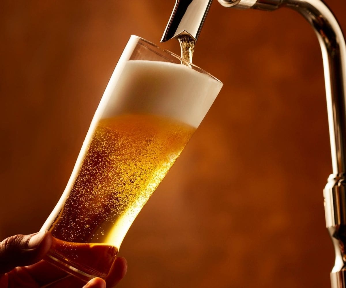 Zlatno craft pivo u čaši s bijelom pjenom